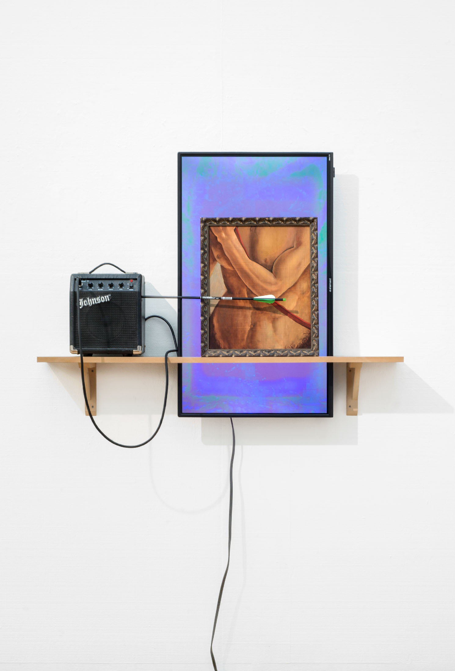a guitar amplifier, flatscreen television mounted in portrait mode, and a painting of a detail of a centaur